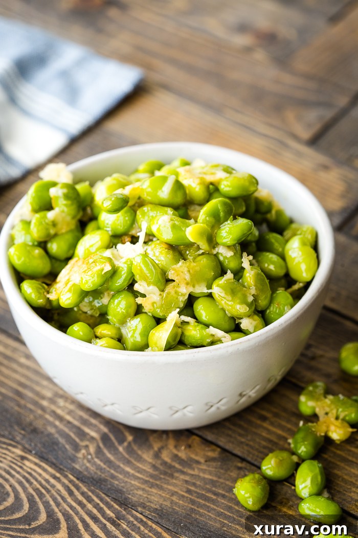 Golden Parmesan Edamame Bites 2 Crispy Parmesan Roasted Edamame served on a white plate