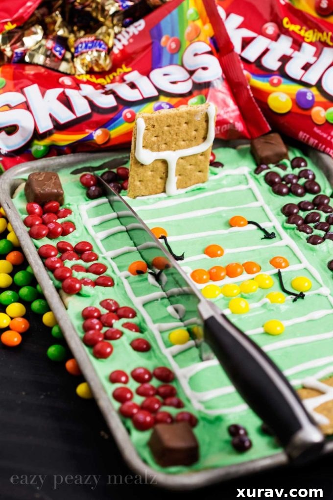 A slice of football stadium sugar cookie bar, showcasing the layers and Skittles.