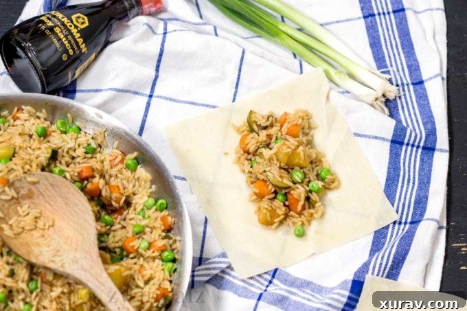 Hands demonstrating how to roll pineapple fried rice into an egg roll wrapper