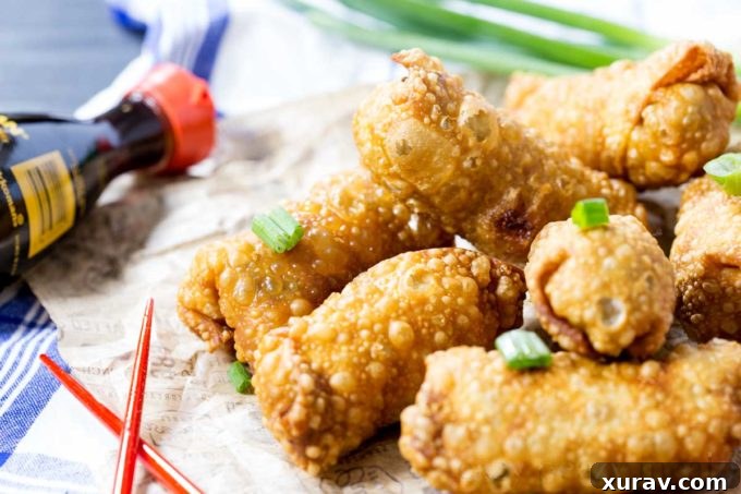 Platter of freshly fried Pineapple Fried Rice Egg Rolls with a dipping sauce