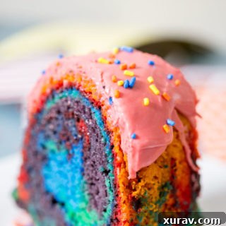 A colorful vanilla bundt cake topped with raspberry glaze.