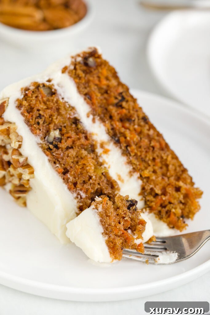 A big slice of moist, spiced carrot cake with a generous layer of cream cheese frosting, ready to be enjoyed with a fork
