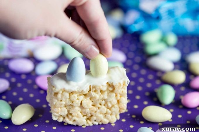 Step 3: Carefully placing pastel Jordan almonds into the melted chocolate on the Rice Krispies Treat basket base.