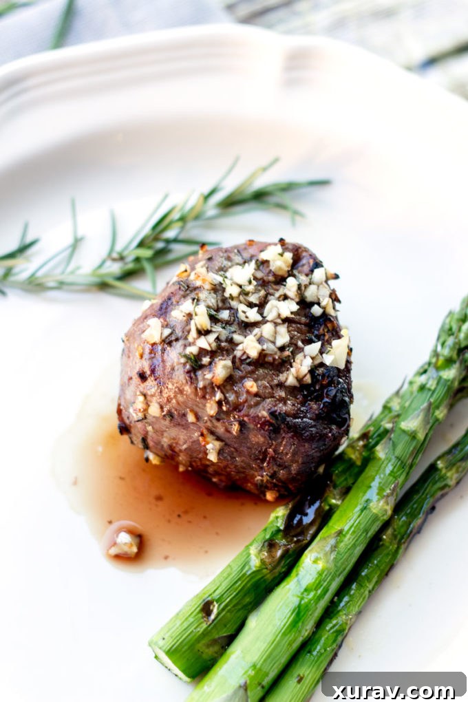 A perfectly grilled 10 Garlic Clove Marinated Grilled Filet Mignon, rich in color and texture, resting on a serving board.