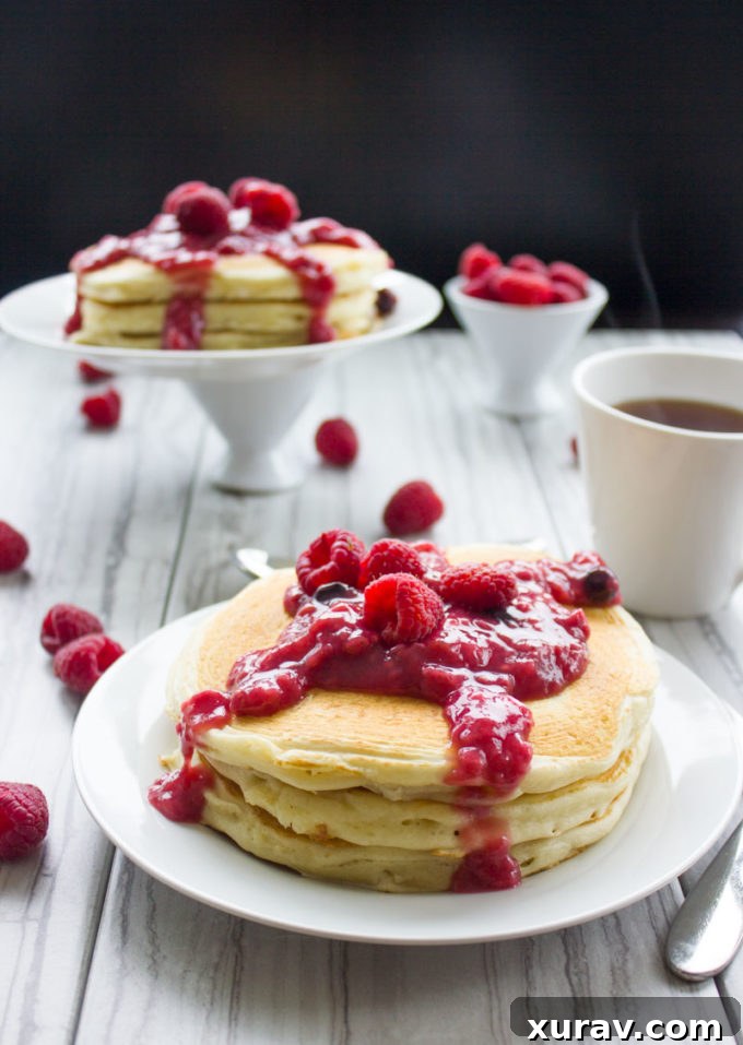 Delicious Raspberry Cheesecake Pancakes drizzled with fresh raspberry sauce