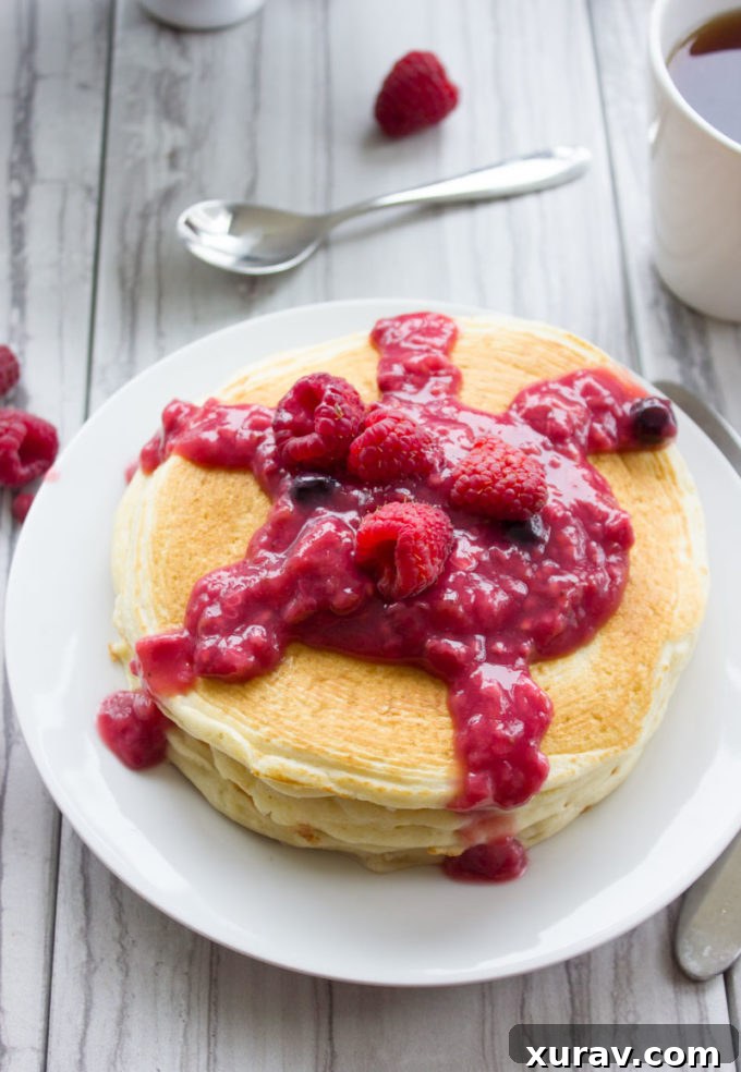 Close-up of fluffy pancakes with cream cheese filling and fresh raspberries