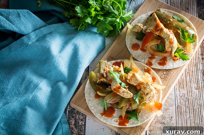 Slow Cooker Chicken Fajitas garnished with fresh cilantro and lime wedges, ready for plating