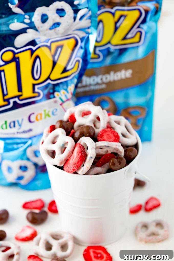 A vibrant Neapolitan Snack Mix showcasing FLIPZ Birthday Cake pretzels, chocolate-covered nuts, and freeze-dried strawberries, perfect for road trips.