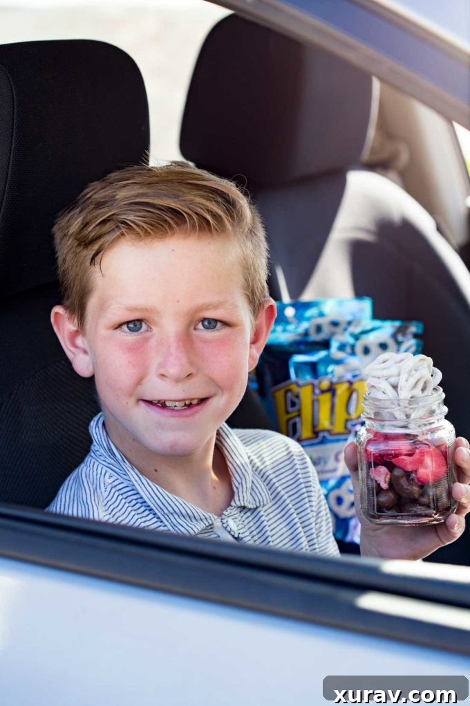 Individual jars filled with Neapolitan Snack Mix, featuring FLIPZ Birthday Cake pretzels, chocolate cashews, and freeze-dried strawberries, ready for distribution.