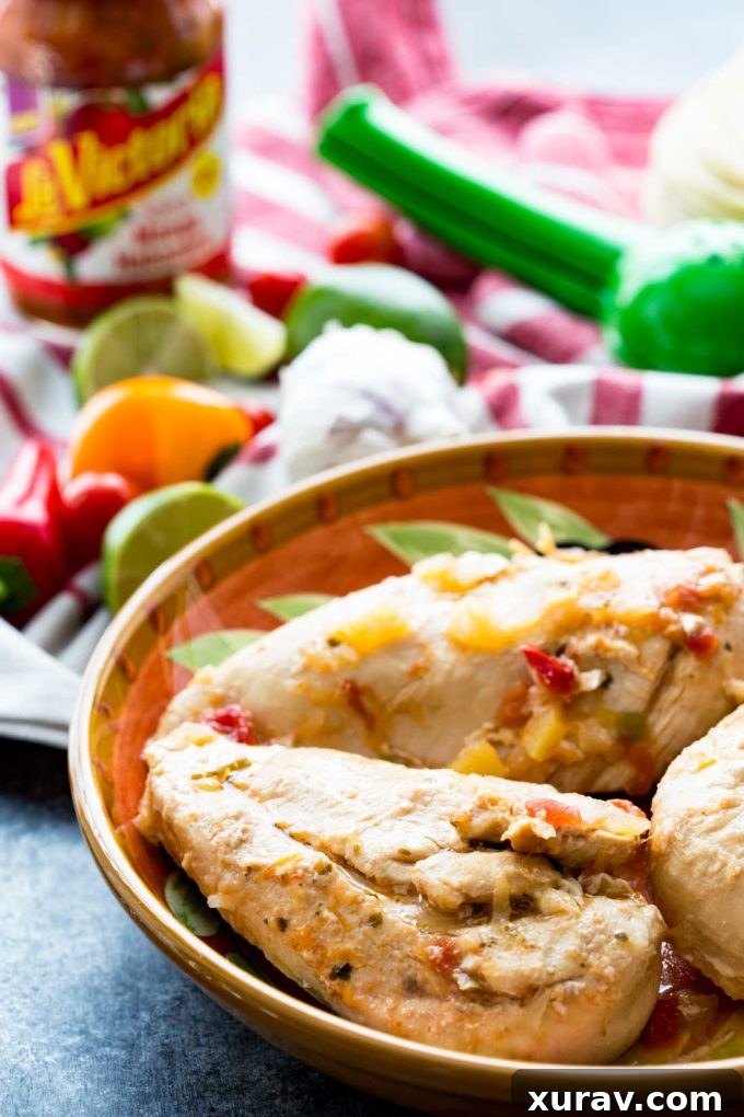 Chicken breasts cooking submerged in a rich mango habanero salsa within a slow cooker, illustrating the hands-off cooking method.