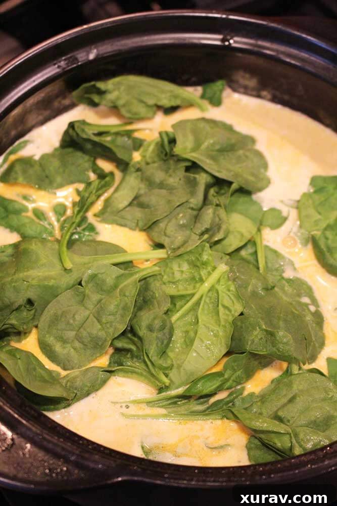 Lemon Butter Chicken with fresh spinach in a skillet