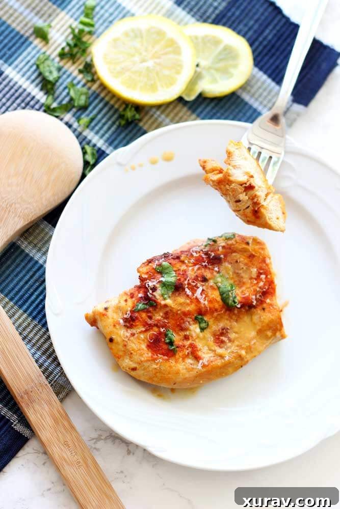 A fork taking a bite of Lemon Butter Chicken with sauce