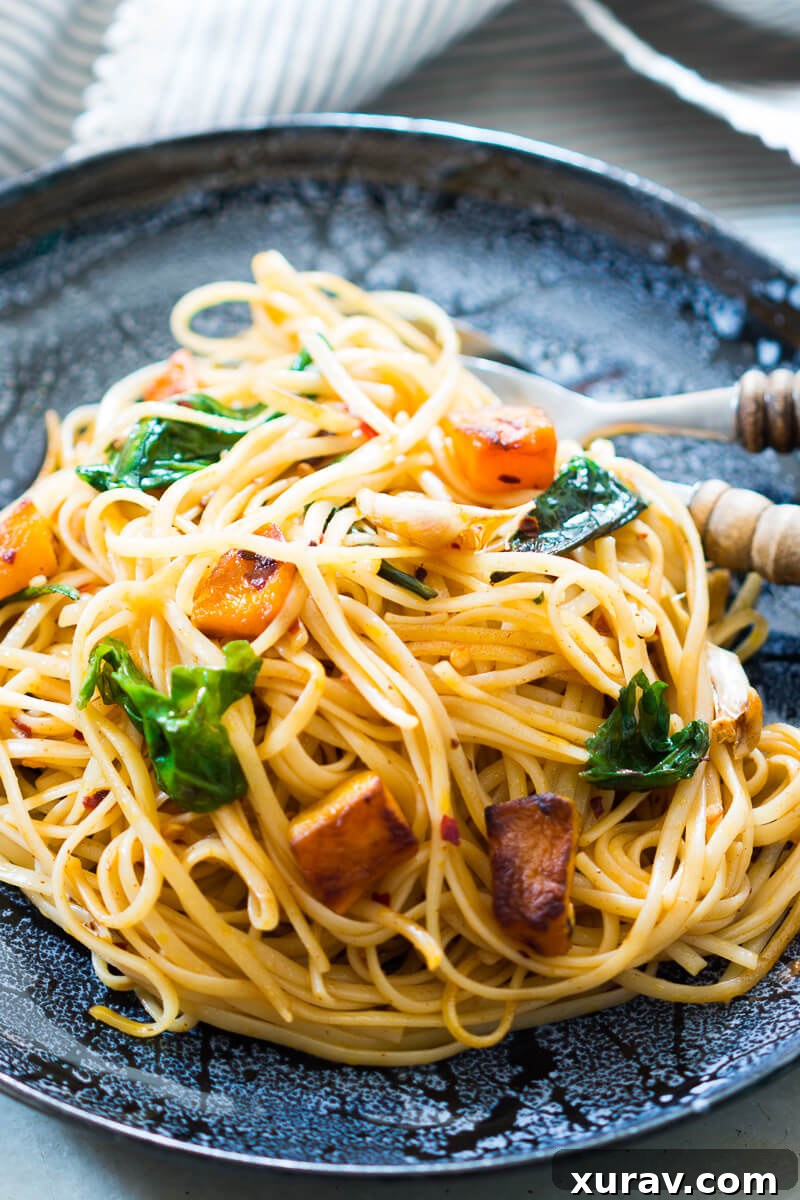 Close-up of roasted pumpkin and spinach linguine on a fork