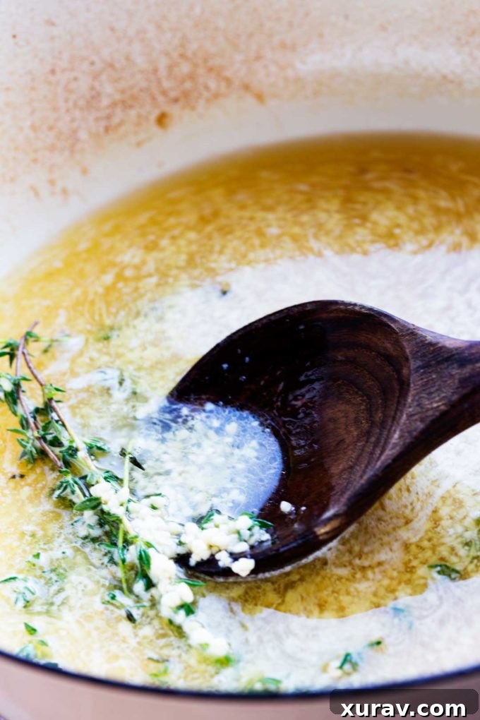 White wine sauce for chicken simmering with fresh thyme
