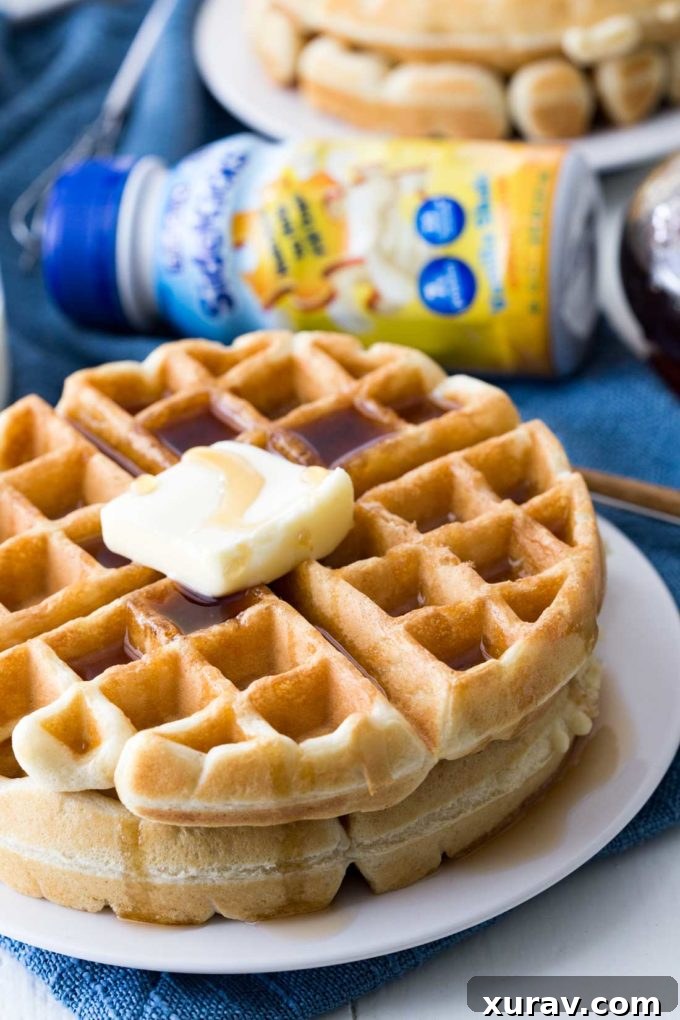 Close-up of classic waffles drizzled with syrup and berries, highlighting their fluffy texture and delicious appeal, made even better with a kid-friendly nutritional boost