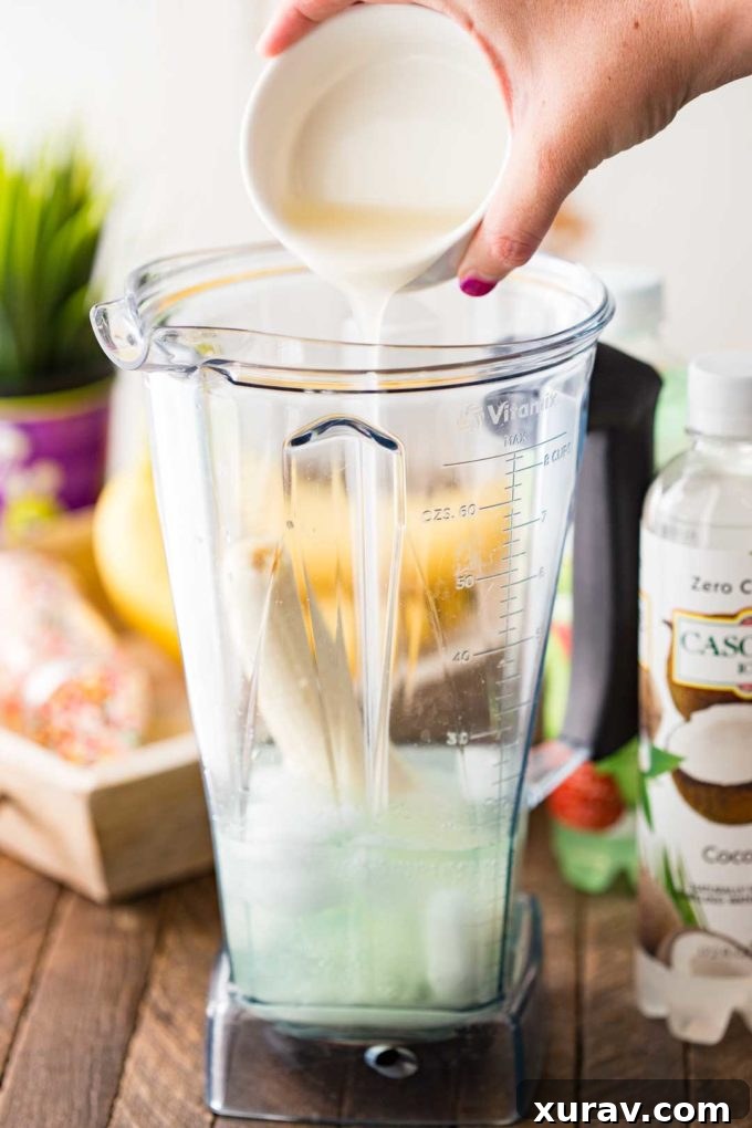 A blender filled with green Halloween punch ingredients, ready to be blended into a smooth potion