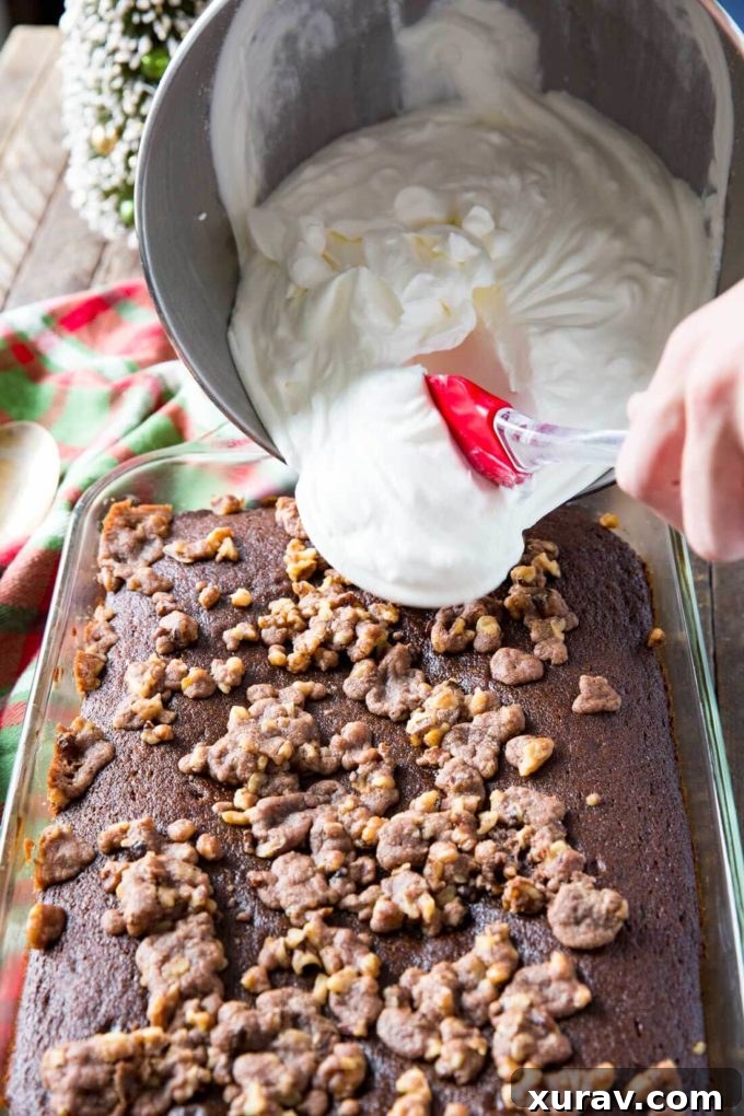 Close-up of a rustic gingerbread cake, showing the rich, dark crumb and hints of spices, ready for a generous topping of whipped cream.
