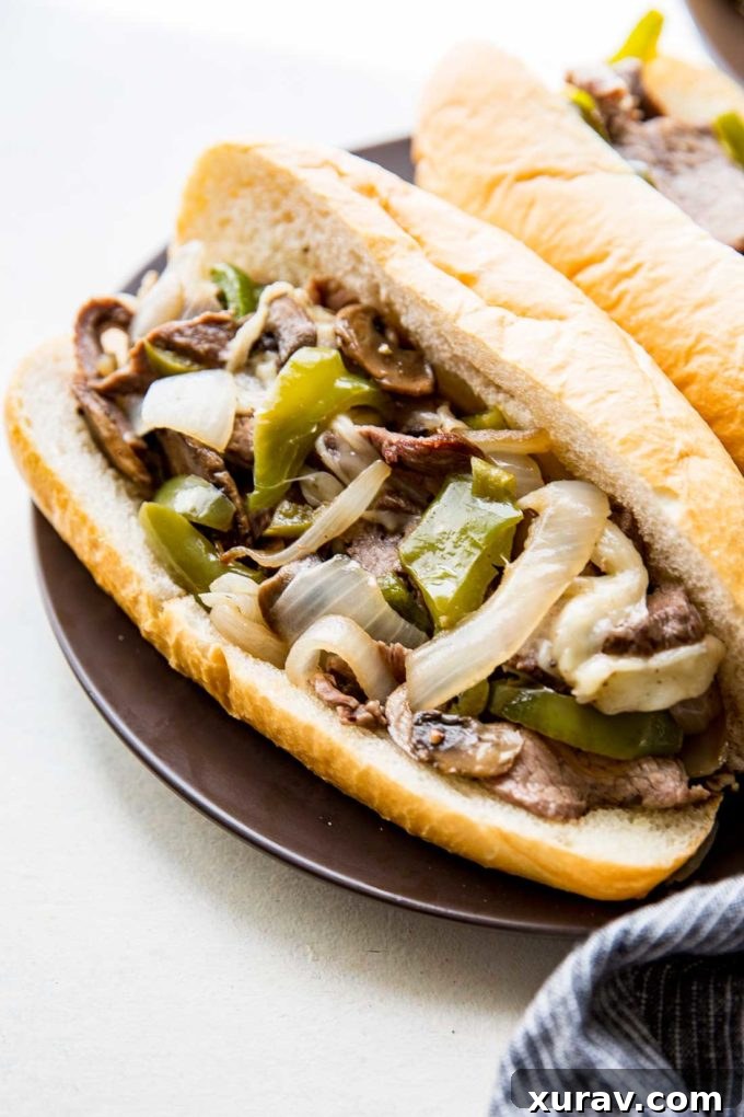 Easy Sheet Pan Philly Cheesesteaks: Tender beef, flavorful peppers and onions, and gooey cheese for a delicious meal.