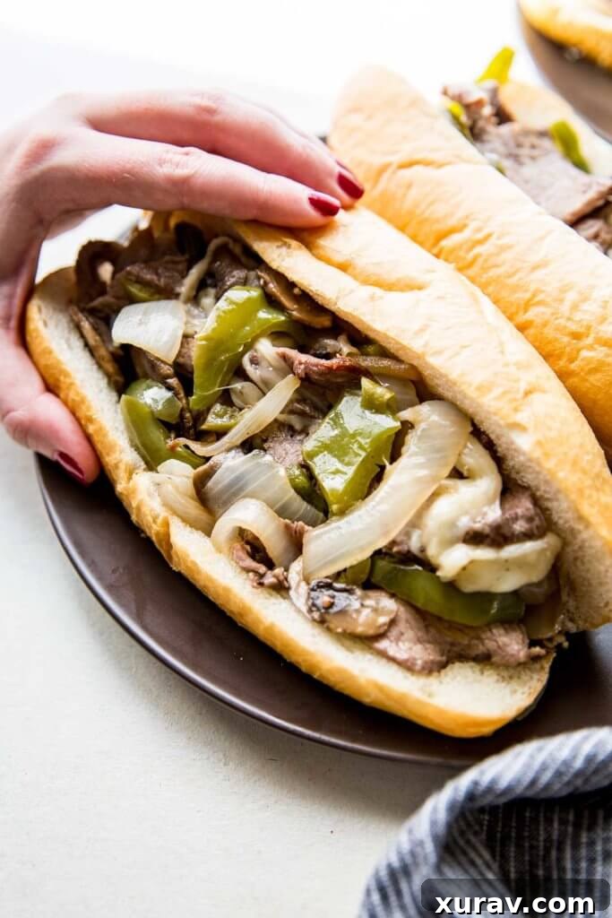 Platter of freshly made Sheet Pan Philly Cheesesteaks on toasted hoagie rolls.