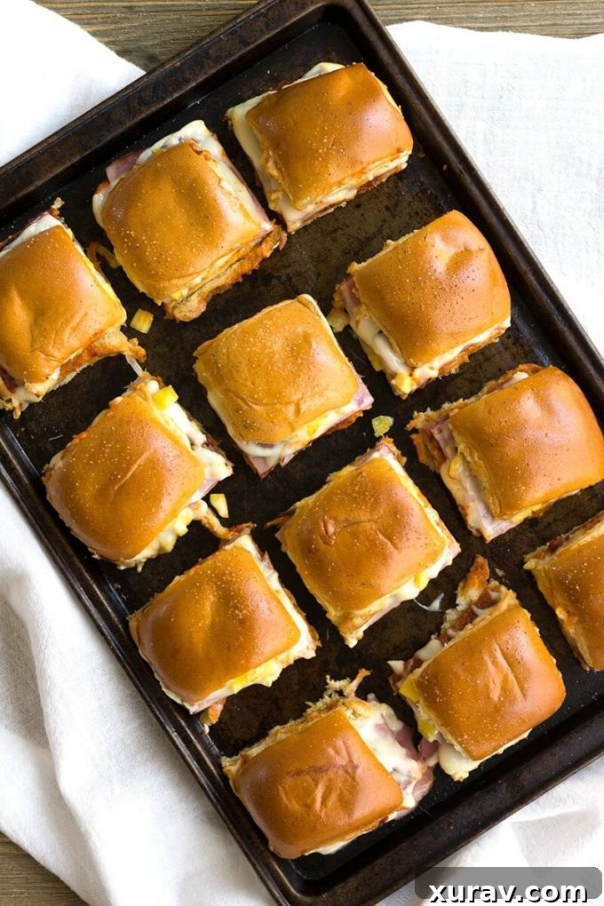 Close-up of freshly baked Hawaiian Pizza Sliders, showing melted cheese and golden-brown rolls, perfect for any party.