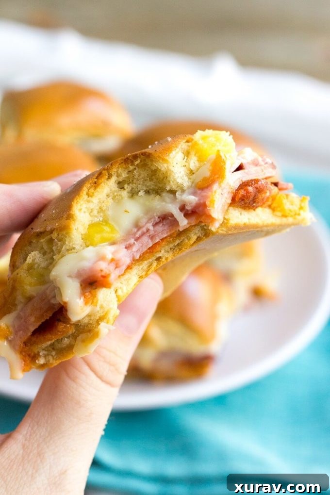 Overhead shot of Hawaiian Pizza Sliders on a baking sheet, ready for the oven, showcasing the layered ingredients.