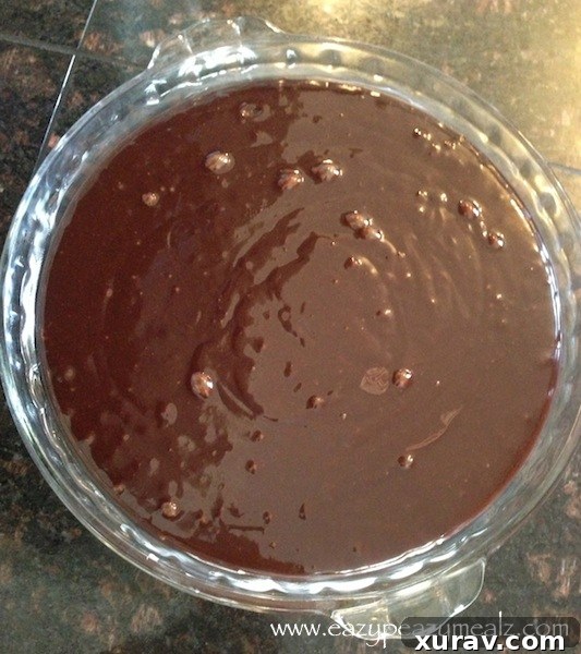 Uncooked chocolate cake batter filling a prepared cake pan