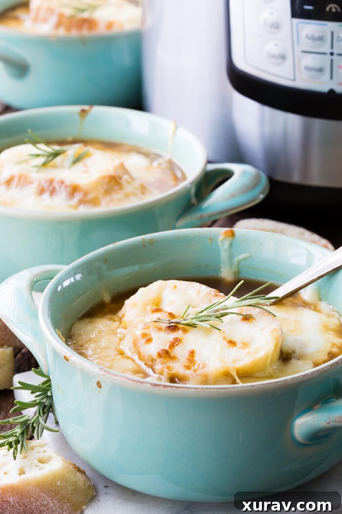 A bowl of Instant Pot French Onion Soup with melted Gruyere cheese and a toasted baguette slice
