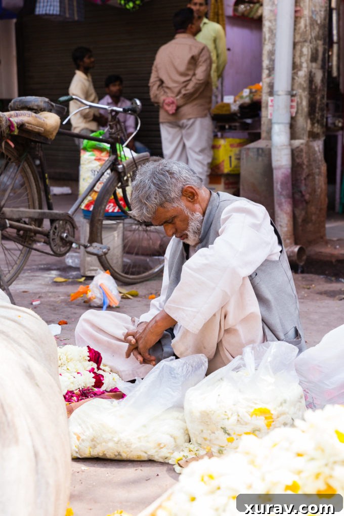 Flower vendor praying in Delhi, a spiritual moment