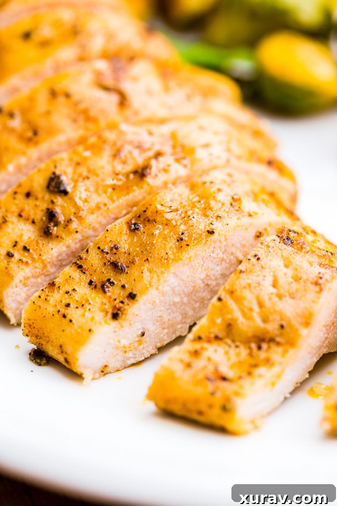 A close-up shot of roasted chicken and Brussels sprouts directly on a sheet pan, showcasing the golden-brown chicken skin and charred vegetable edges.