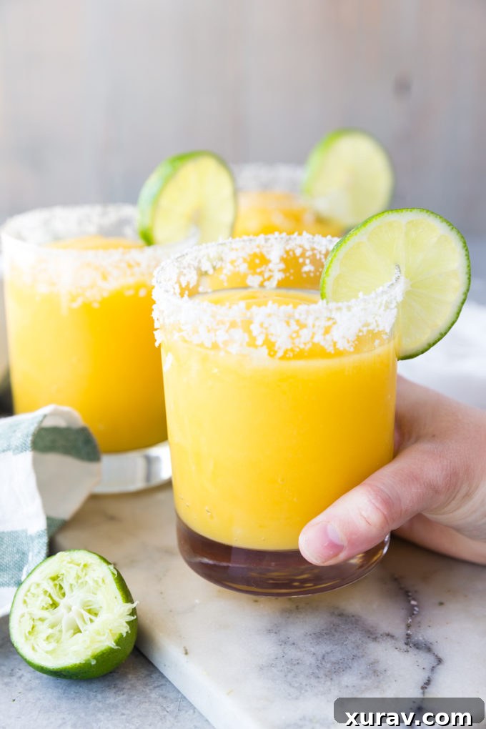 Mango Margaritas raise a glass, salted rim, with lime, frozen