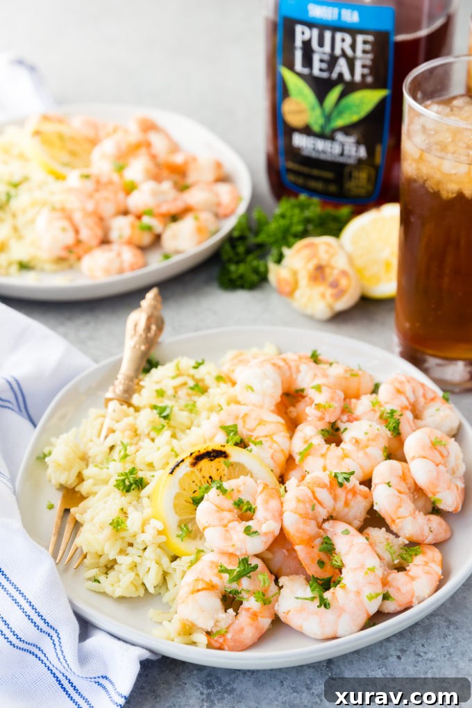 A beautifully plated dish of Garlic Butter Shrimp garnished with fresh parsley and lemon slices, ready to be served.
