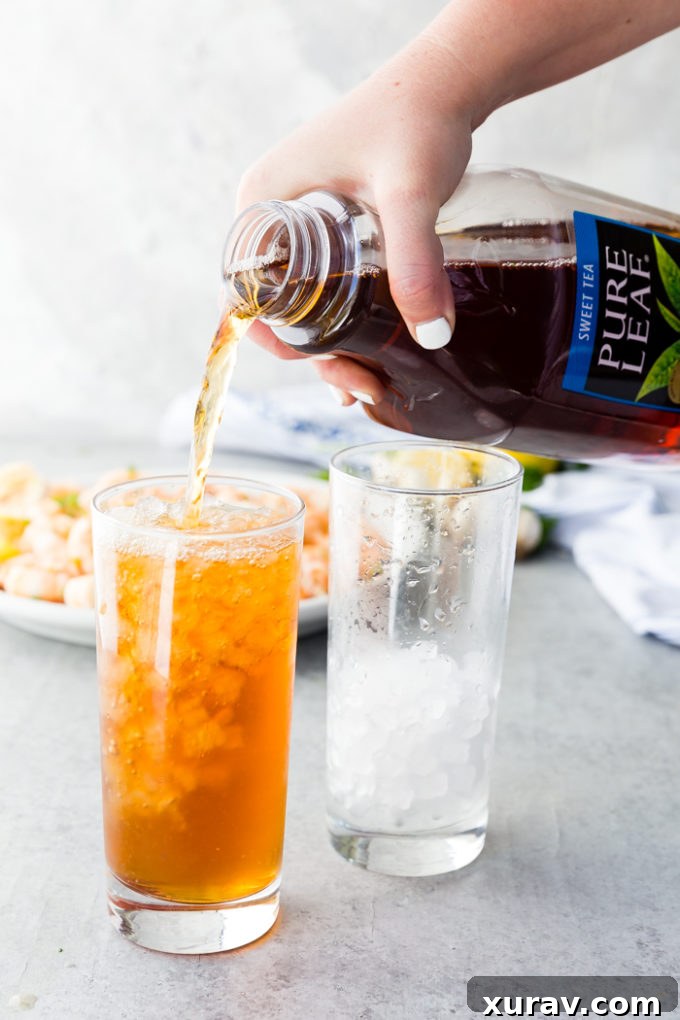 A close-up shot of raw shrimp ready for cooking in a pan, next to fresh parsley and lemon slices.