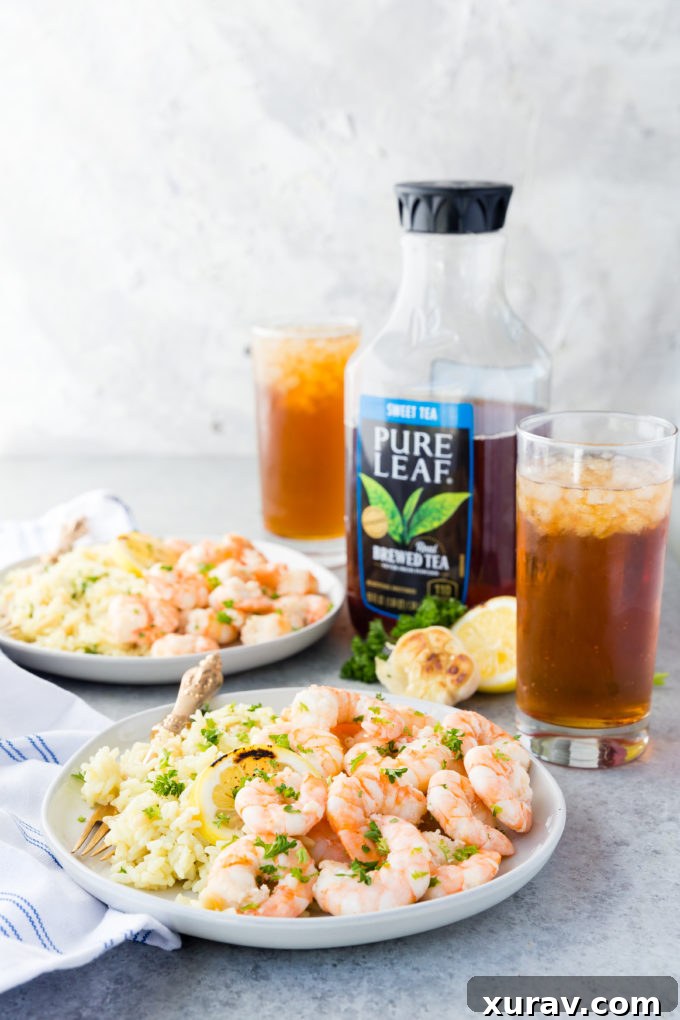 A vibrant summer meal spread featuring garlic butter shrimp, rice pilaf, and Pure Leaf Sweet Iced Tea in glasses.