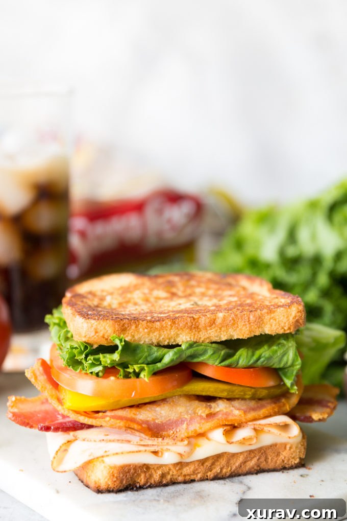 Effortless Chicken Club Stack 5 A beautifully layered chicken club sandwich, cut in half to reveal all its delicious components.