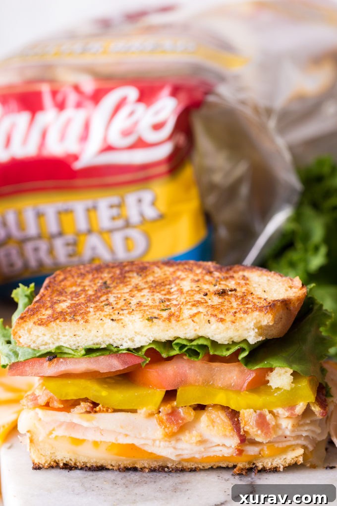 Effortless Chicken Club Stack 6 Delicious Sara Lee Butter Bread chicken club sandwich, cut in half and ready to eat.