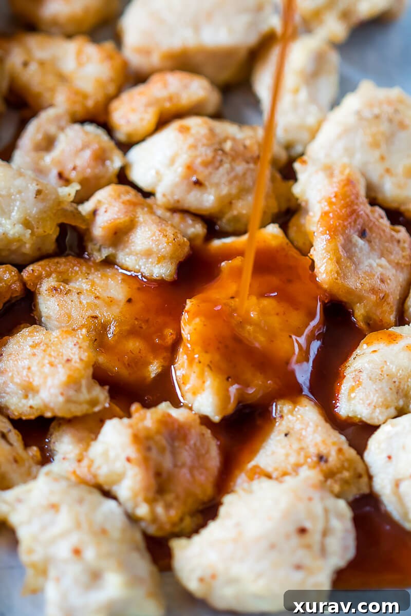 Saucing the baked orange chicken