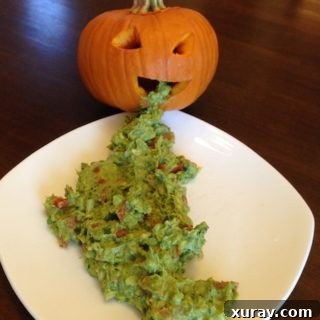 Close-up of the Halloween Pumpkin Puke Guacamole, spilling out from a carved pumpkin.