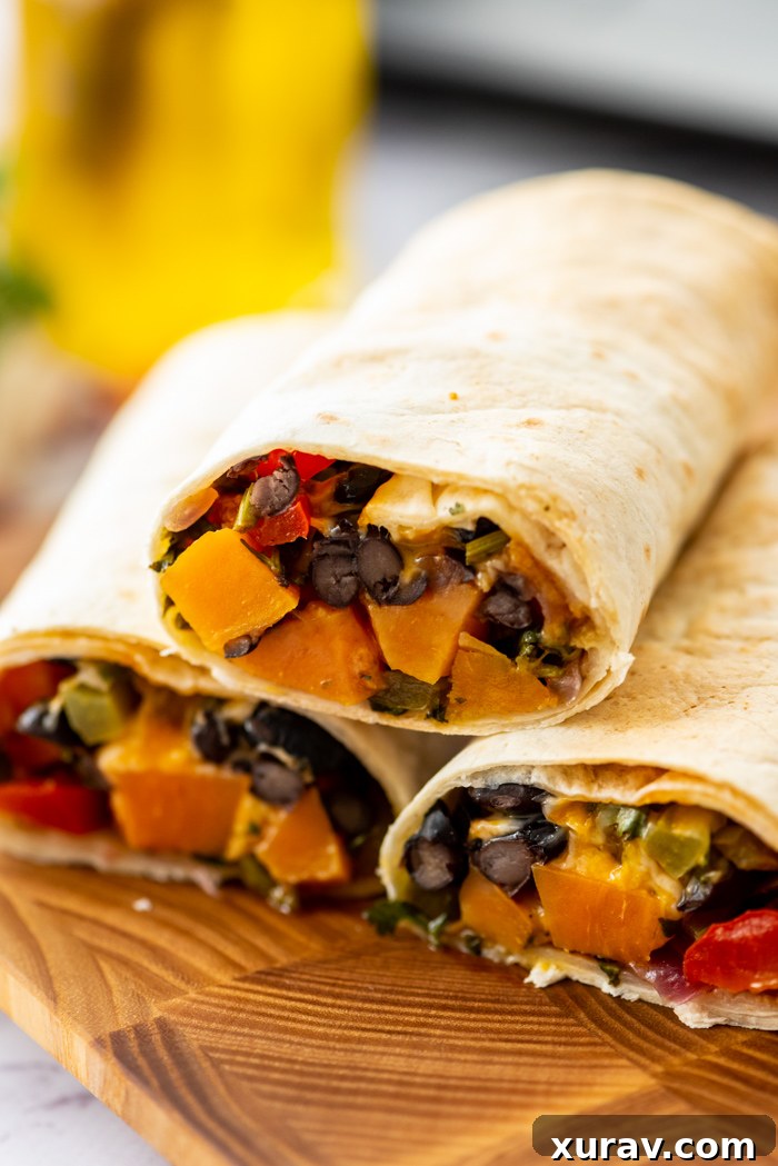 Close-up of fresh ingredients: diced sweet potatoes, red onions, and jalapeños, ready for roasting.