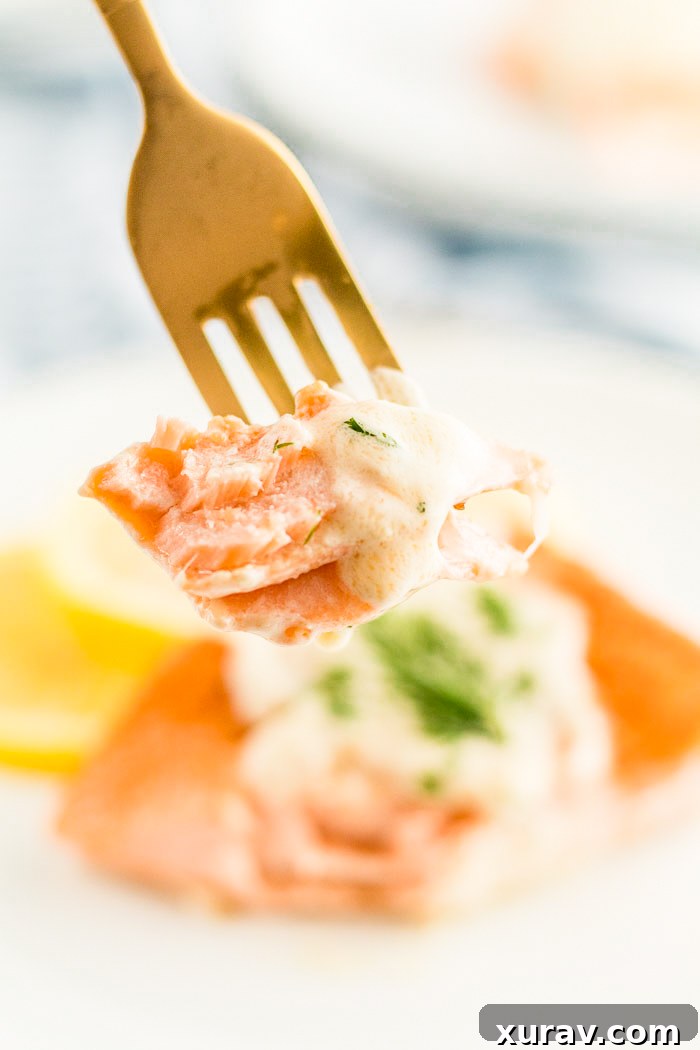 A fork full of salmon made with a creamy lemon dill sauce