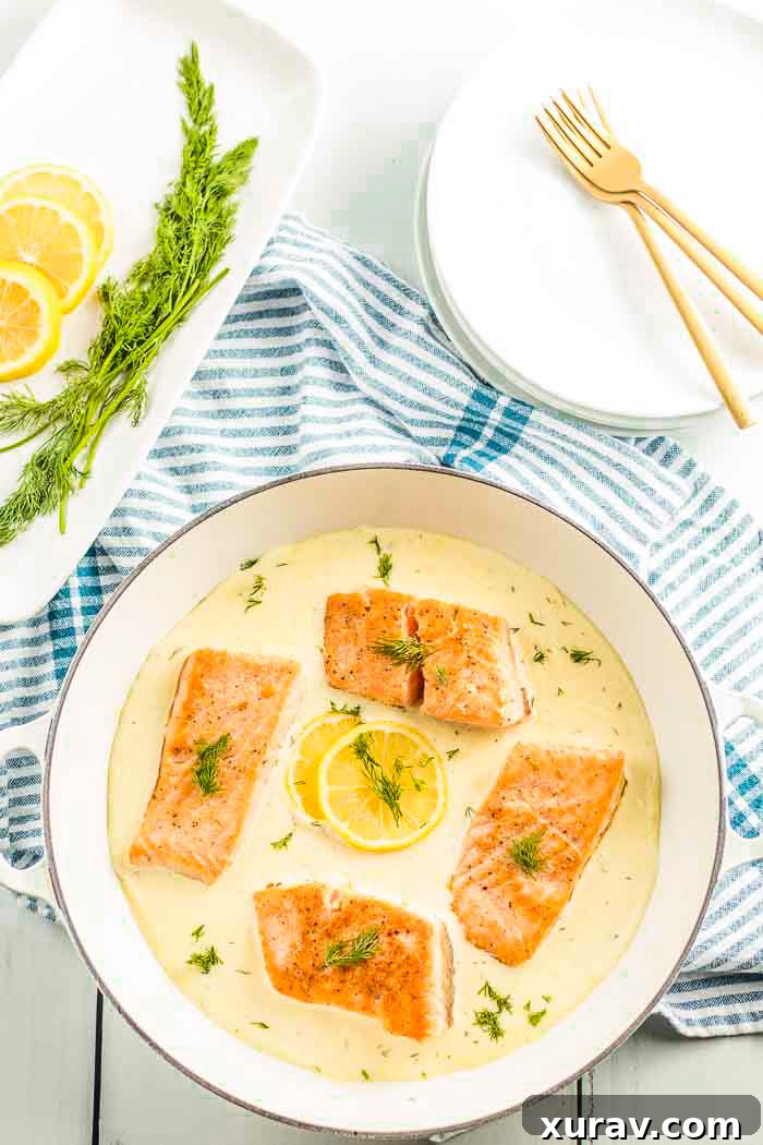 A pan full of salmon swimming in a luscious creamy lemon dill sauce