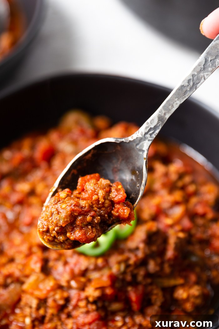 A bowl and spoonful of beanless keto chili, ready to be enjoyed