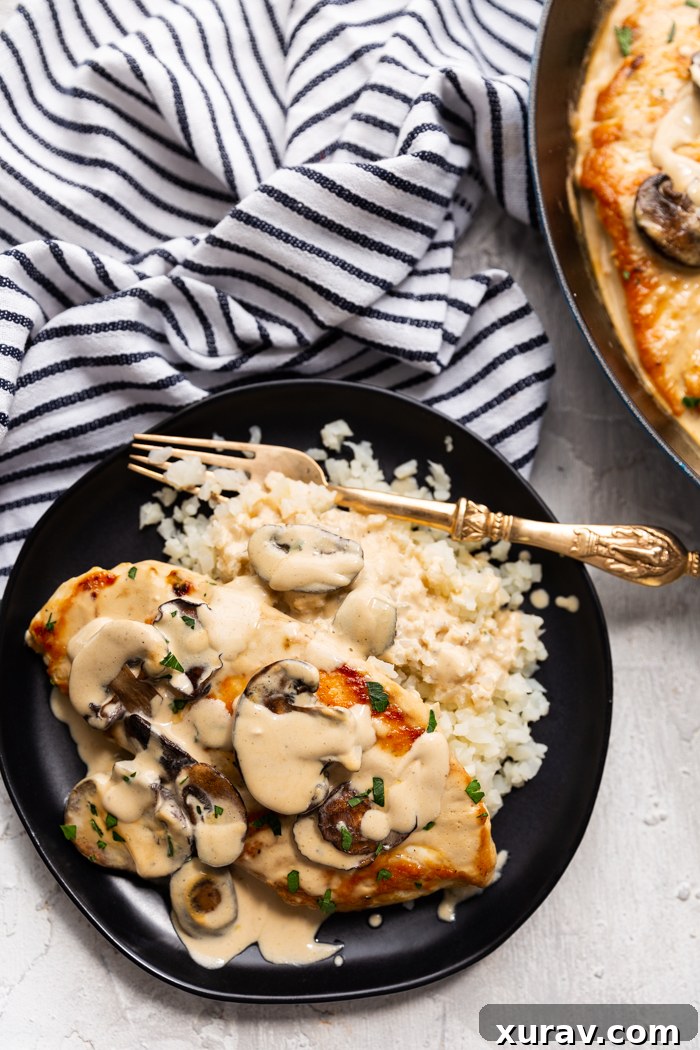 Chicken marsala, a creamy chicken dish served over cauliflower rice and garnished with fresh parsley