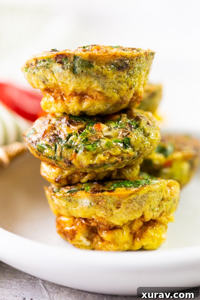 mixed veggies sausage egg cups stacked up on a white plate