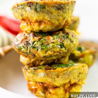 mixed veggies sausage egg cups stacked up on a white plate