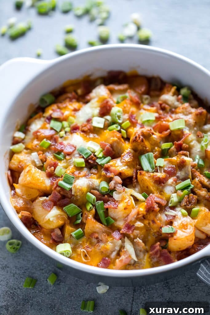 Buffalo Chicken Casserole in white dish, garnished with green onions and bacon