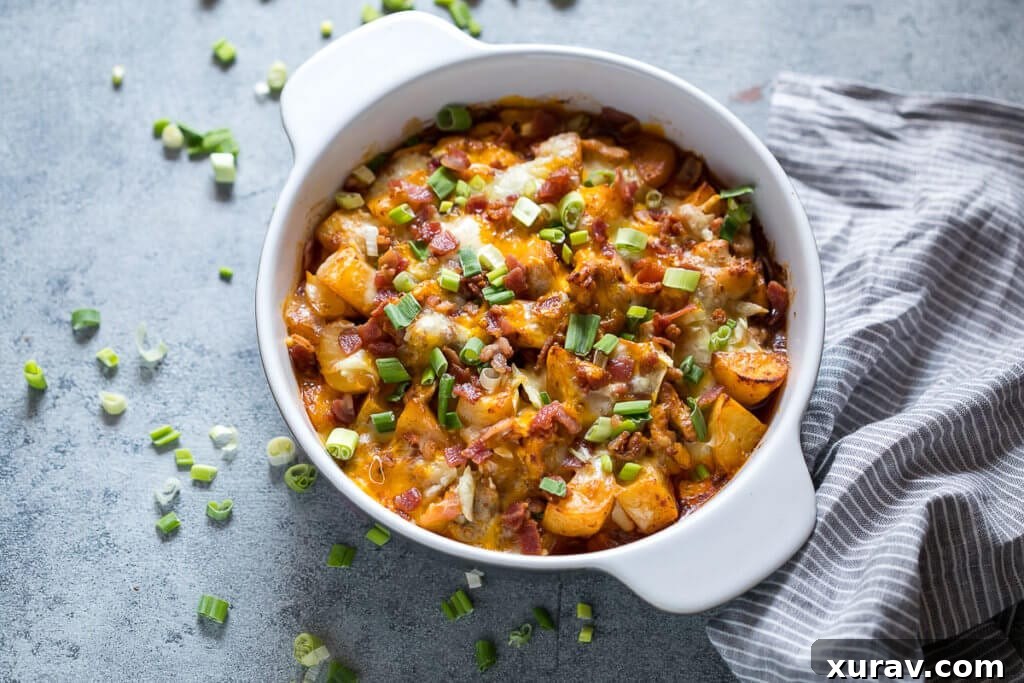 Close-up of Buffalo Chicken Casserole in white bowl, showing melted cheese and crispy bits