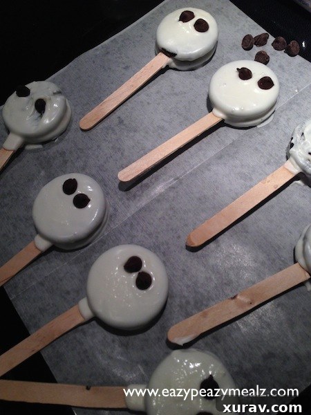 Mummy Oreos with eyes placed, before bandage drizzling