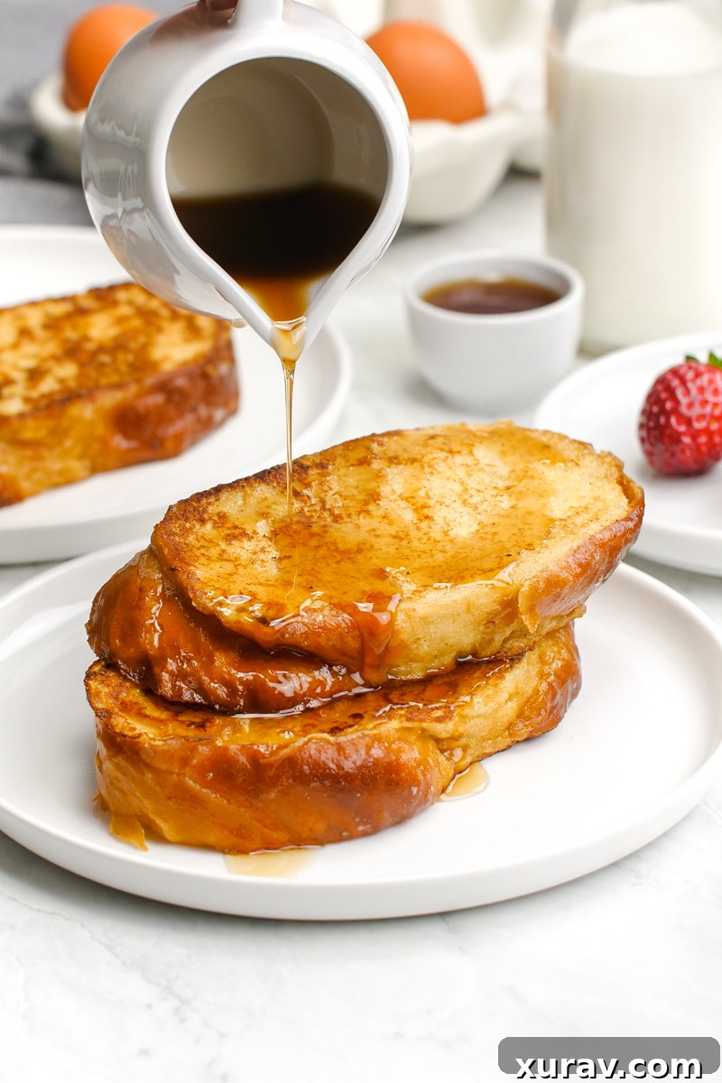Classic french toast, a stack of two french toast slices with syrup being drizzled over the top. 