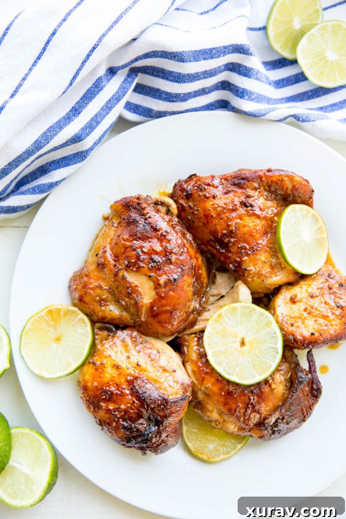 Garlic Lime Chicken on white plate garnished with fresh cut lime.