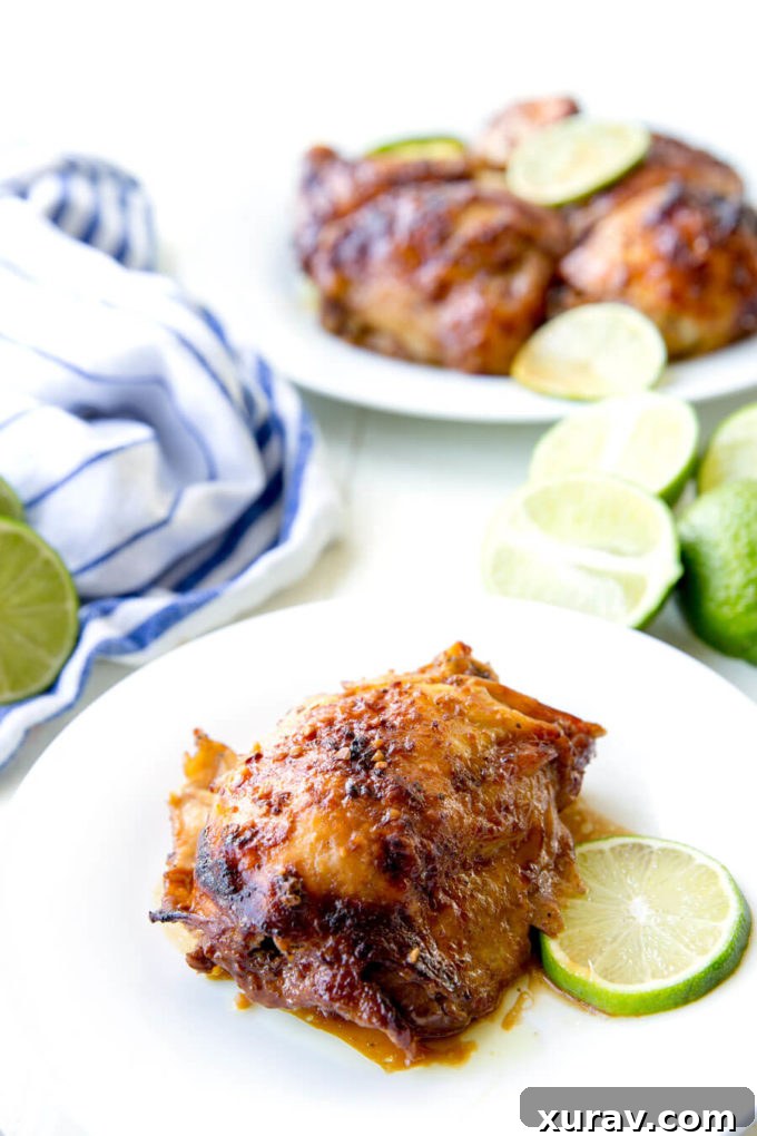 Crockpot Garlic Lime Chicken on white plate with a fresh slice of lime.